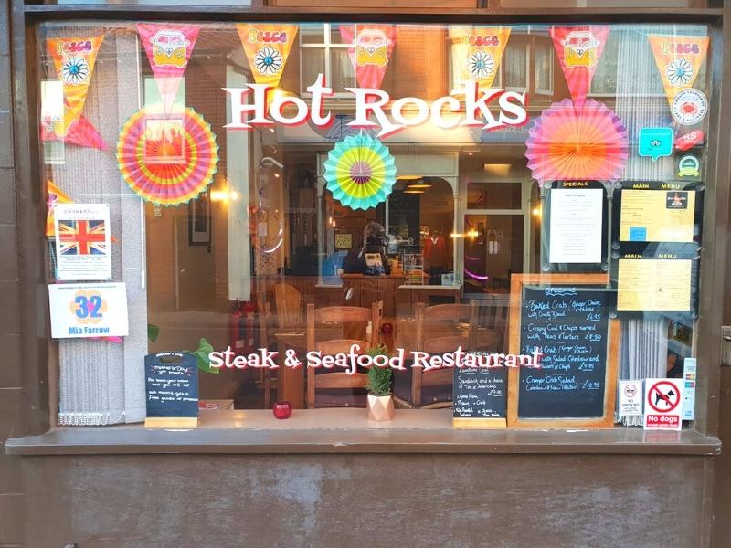 Window into a restaurant with colourful flags and paper decorations