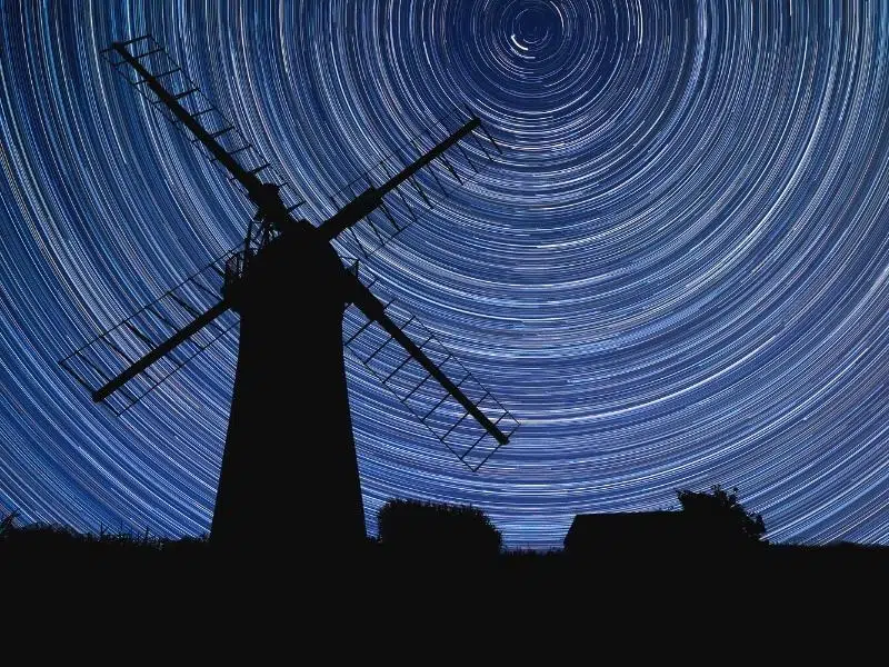 silhouette of a traditional Norfolk windmill against a background of a starry sky 