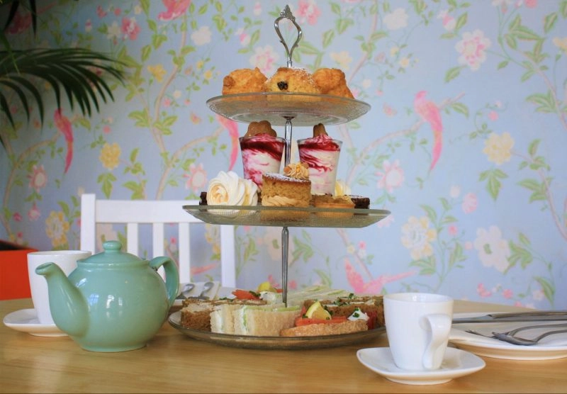 cake stand with sandwiches, scones and cakes