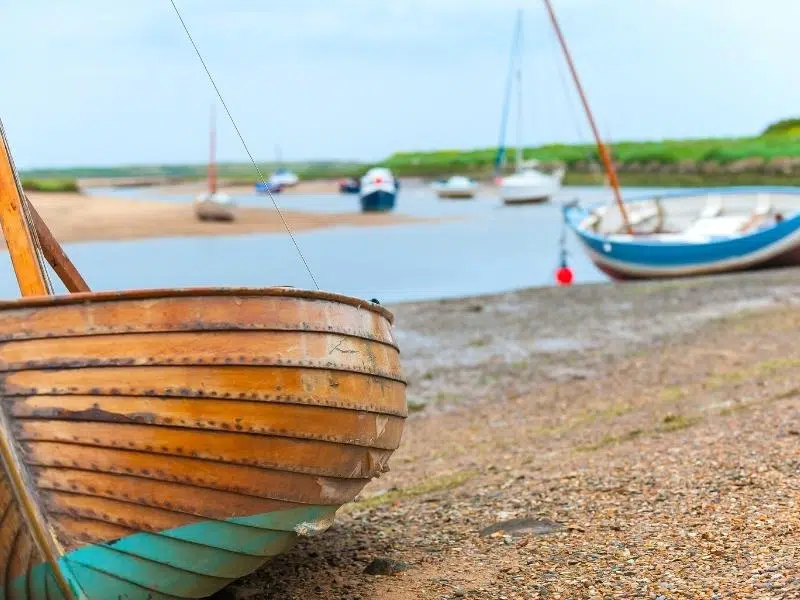 colourful boats grounded on salt flats at loew tide