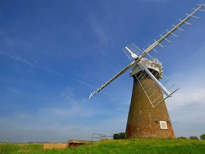 red brick wind pump on a grassy mound