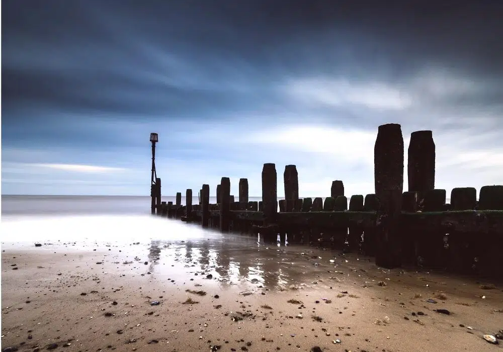 wooden groins on a beach stretching into the sea