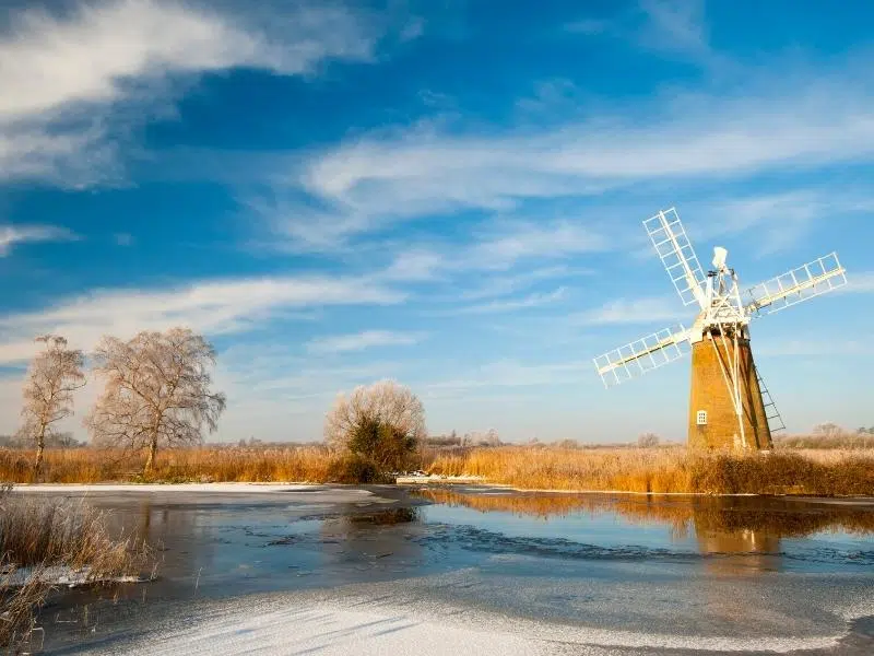Turf fen wind pump in winter with ice on the surrounding broad
