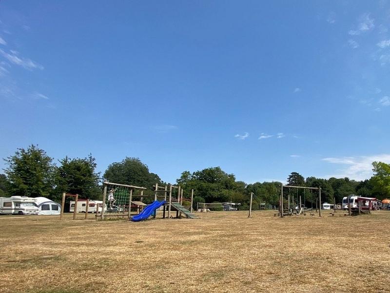 Childrens play area on parched grass in a campsite in Norfolk