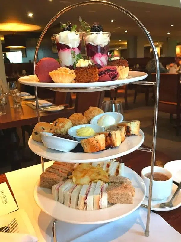 three tier cake stand with afternoon tea arranged on it