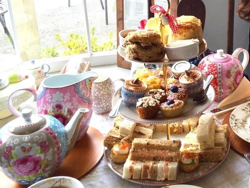 afternnon tea stand with pink blue and grey teapot and milk jug 