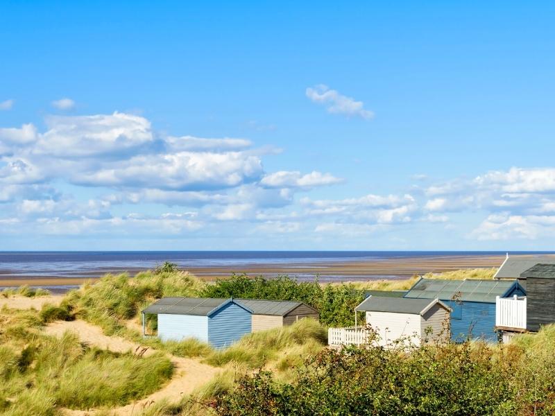 blue and white painted beach huts on Old Hunstanton Beach