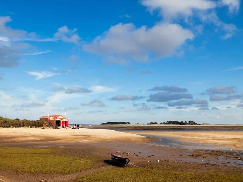 red and yellow lifeboat house on sandy beach