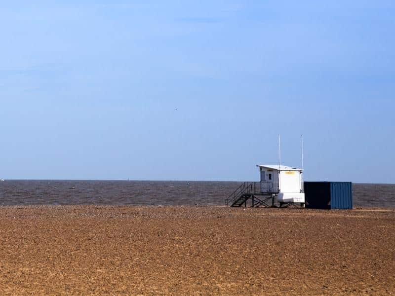 wide beache with sea and white lifeguard hut