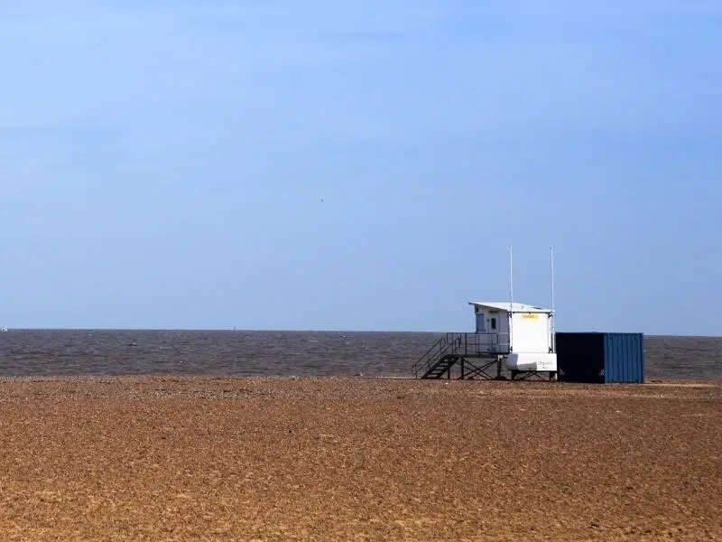 wide beache with sea and white lifeguard hut