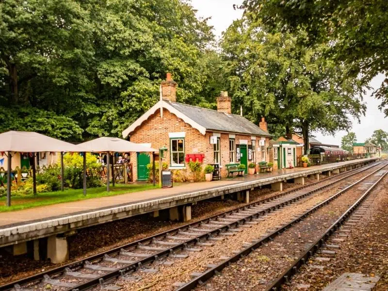 Holt railway station with railways tracks and surrounded by trees