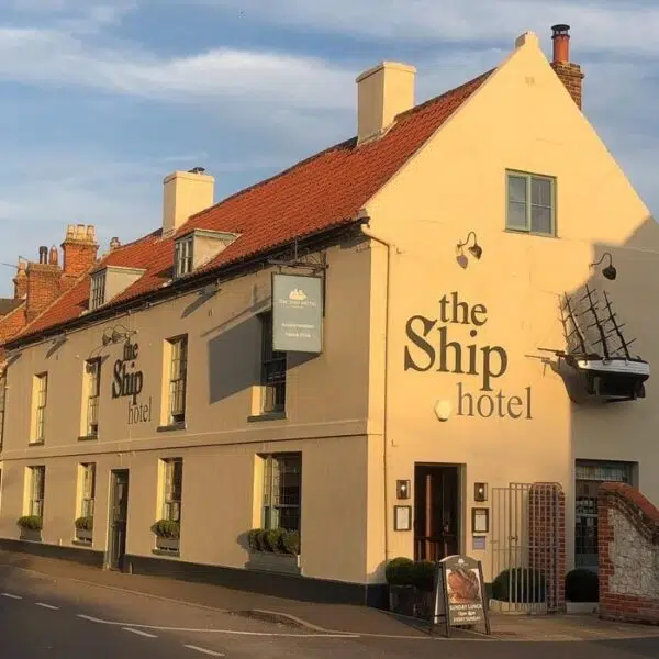 An image of the side of the Ship Hotel, a yellow building bathed in sunlight