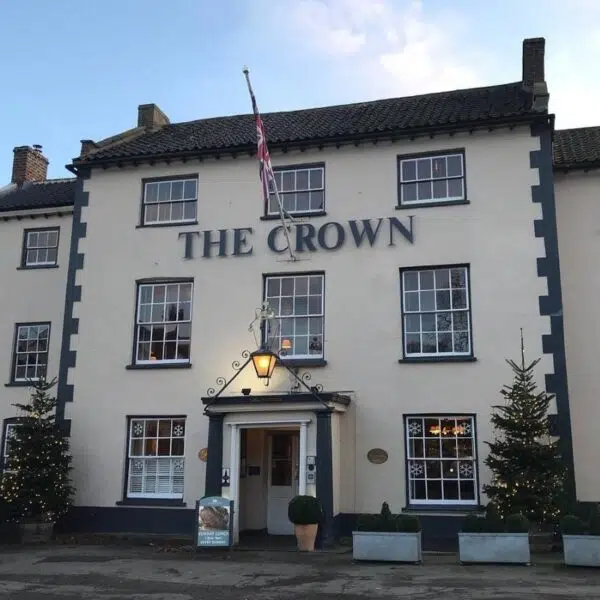 An image of the Front of The Crown hotel, A white building with 9 windows and a UK flag