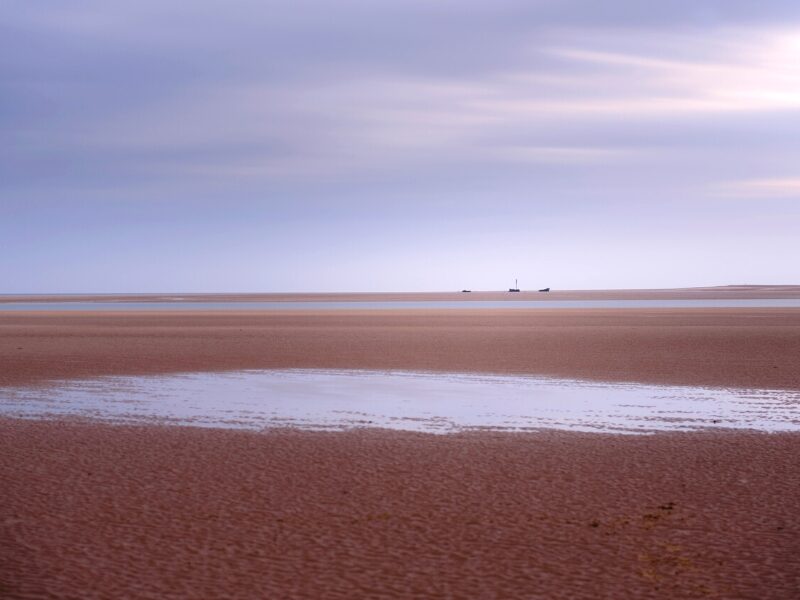 Brancaster beach with a ship wreck in the distance