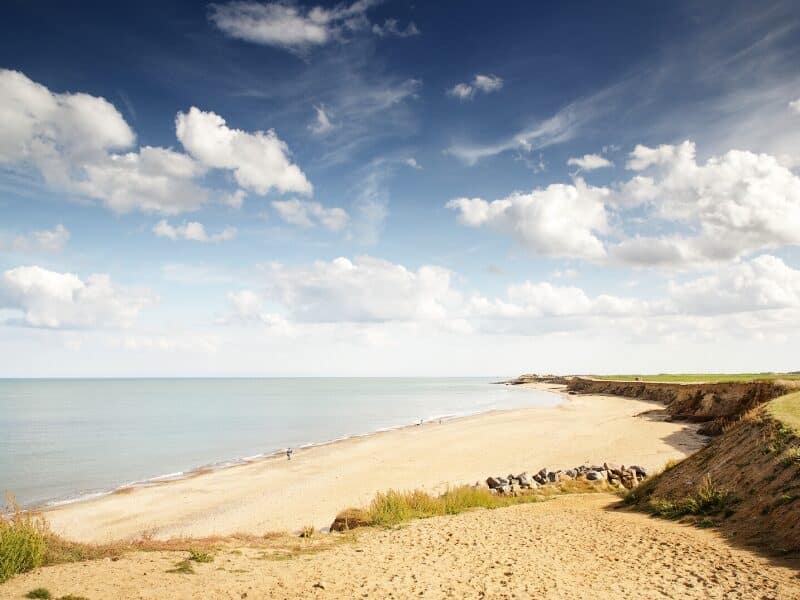 Wide bay backed by low grassy cliffs