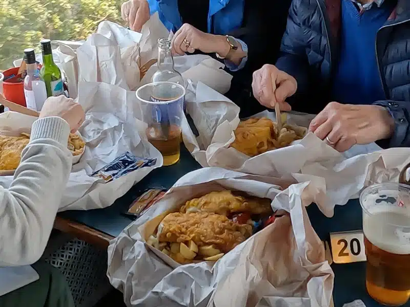 Fish and chips in open wrappers