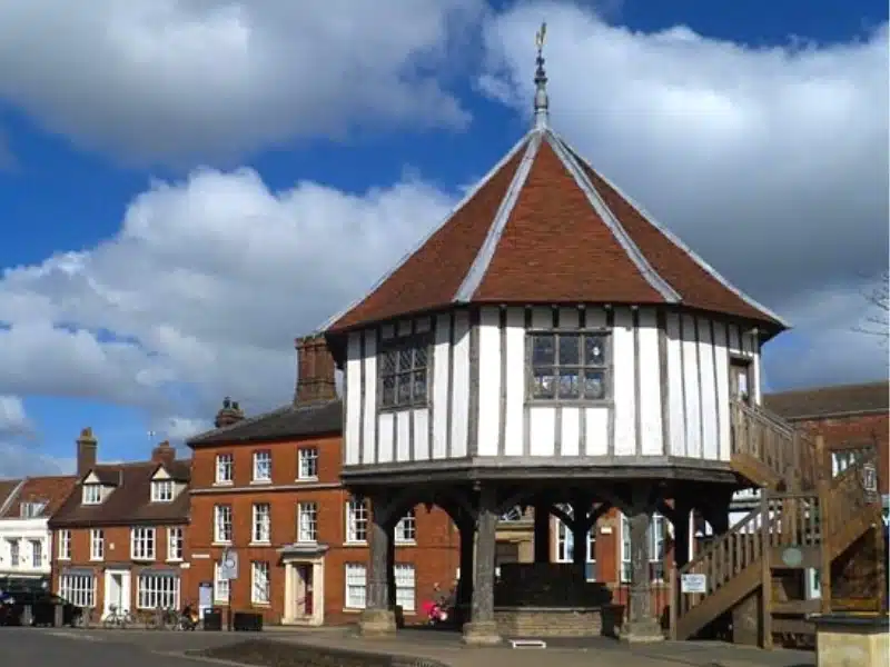 White half timbered octagonal house on stilts with a wooden staircase