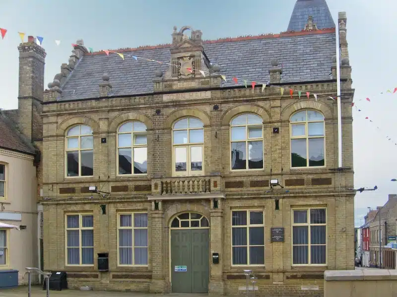 Georgian town hall building with large windows and oval topped double front door.