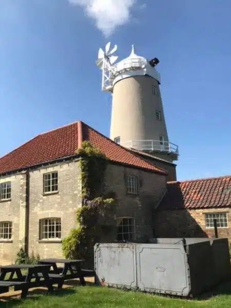 A windmill with no sails behind a Georgian building