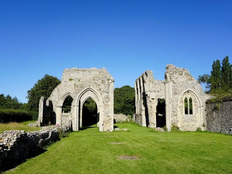 Stone ruins of an ancient abbey in a grassy mown field