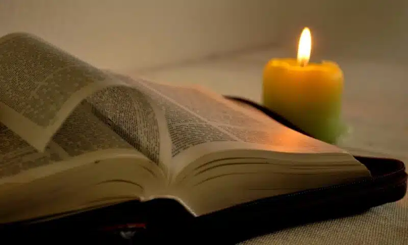 book and lit candle on a table