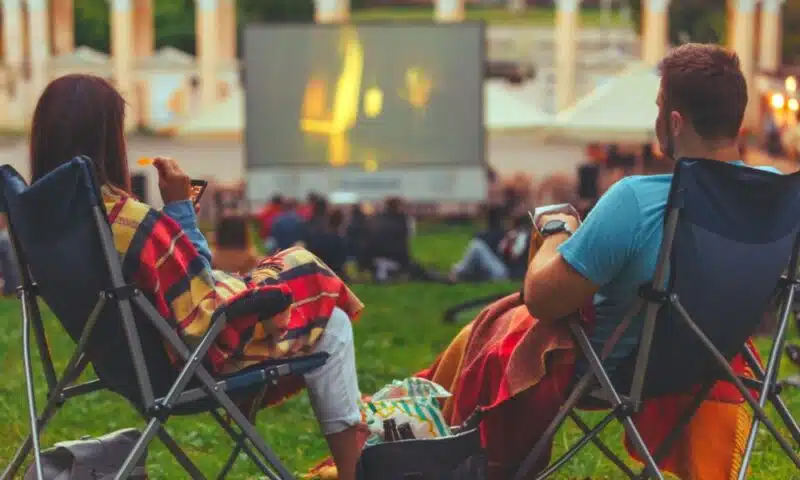 People in camping chairs watching outdoor movie