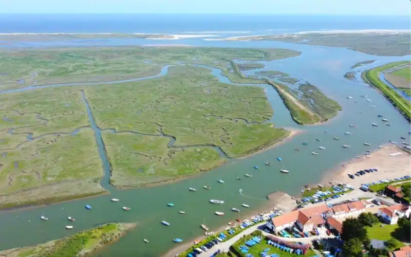 Drone shot of Burnham Overy Staithe showing the salt marjes and creeks with the beach n the distance