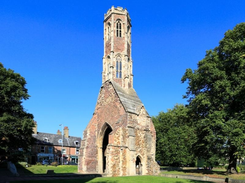 tall octagonal tower surrouned by grass and trees